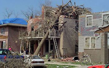 houses and cars destroyed by a tree fallen after a tornado